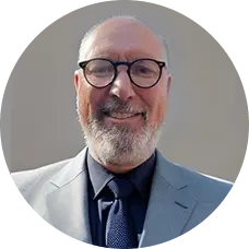 Professional headshot of a man with glasses.